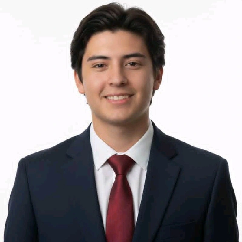 Ian Mendoza, CTO and Co-Founder of Sorta, in a blue suit, white shirt, and red tie